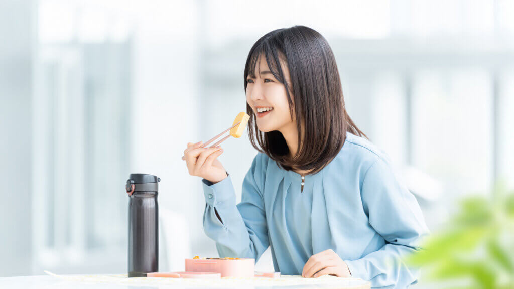オフィスでランチタイムに健康的な食事をとる女性